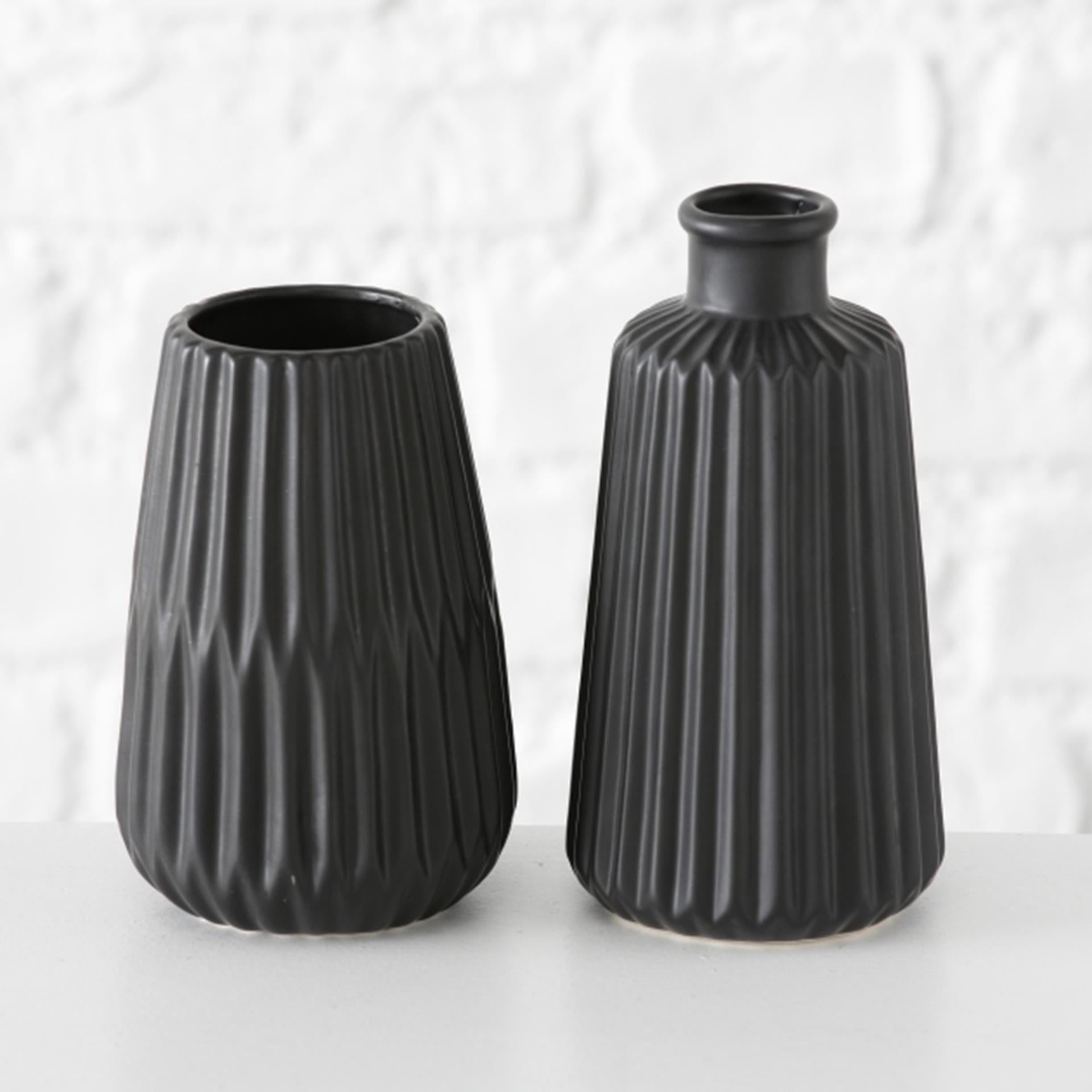 The Boltze Home Vase Esko in black porcelain, placed on a wooden table, holding a small bouquet of flowers