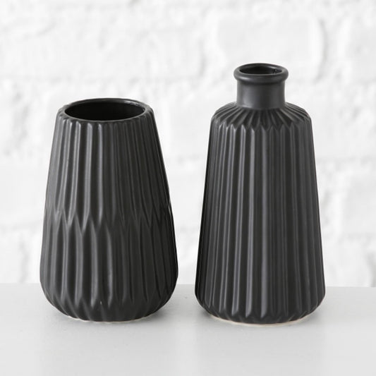The Boltze Home Vase Esko in black porcelain, placed on a wooden table, holding a small bouquet of flowers