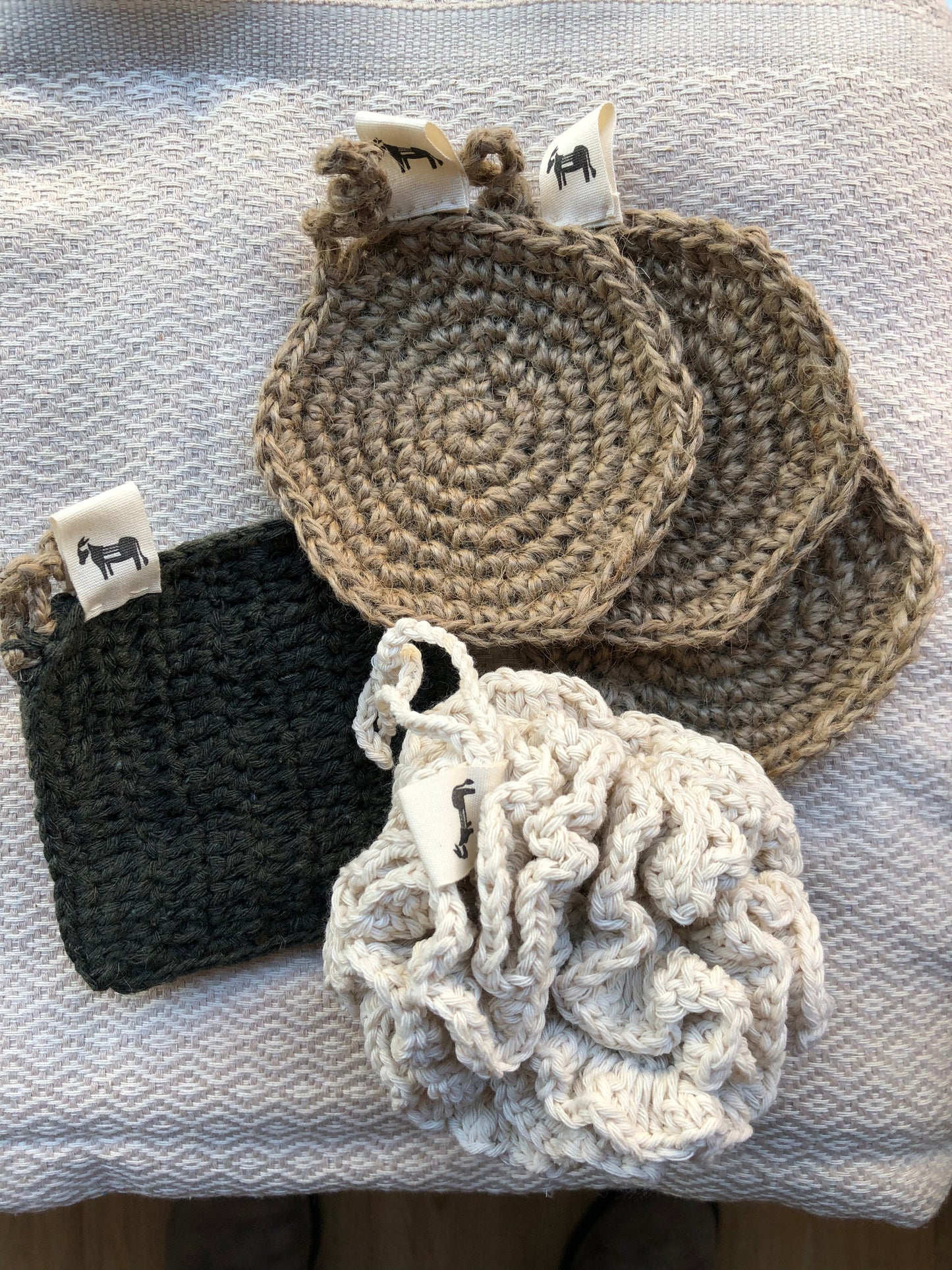 Handcrafted jute scrubber 'Flat Earth' on a natural wood background, styled for bathroom use.