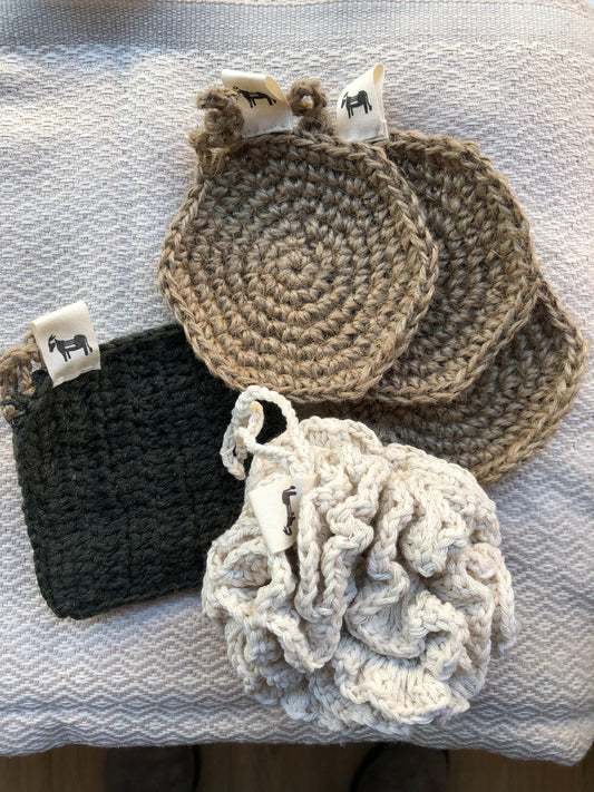 Handcrafted jute scrubber 'Flat Earth' on a natural wood background, styled for bathroom use.