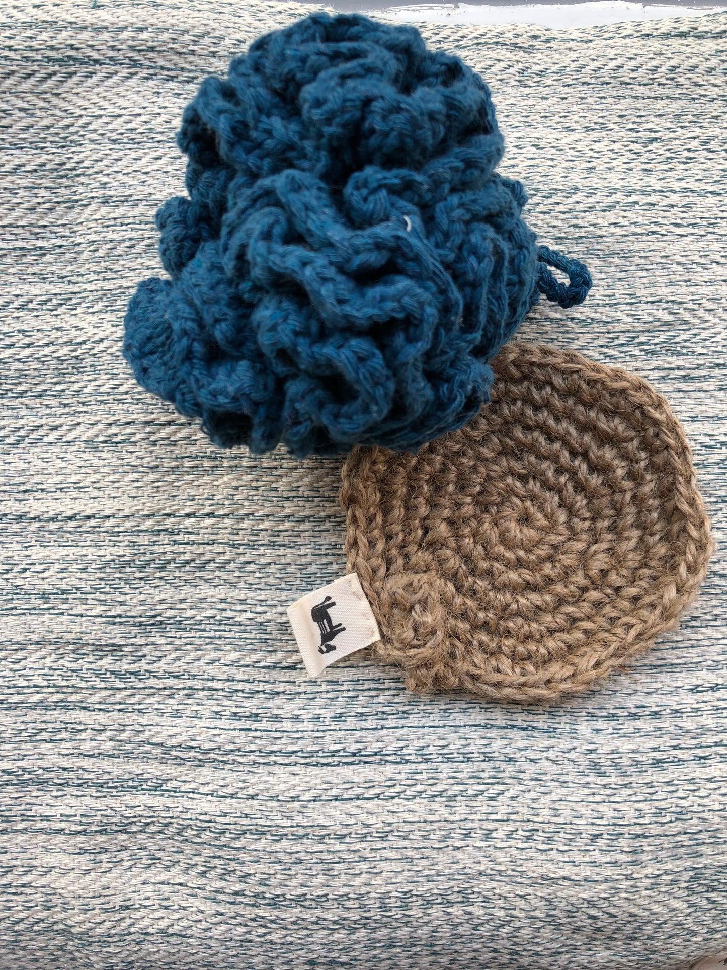 Handcrafted jute scrubber 'Flat Earth' in use, cleaning a non-stick pan.