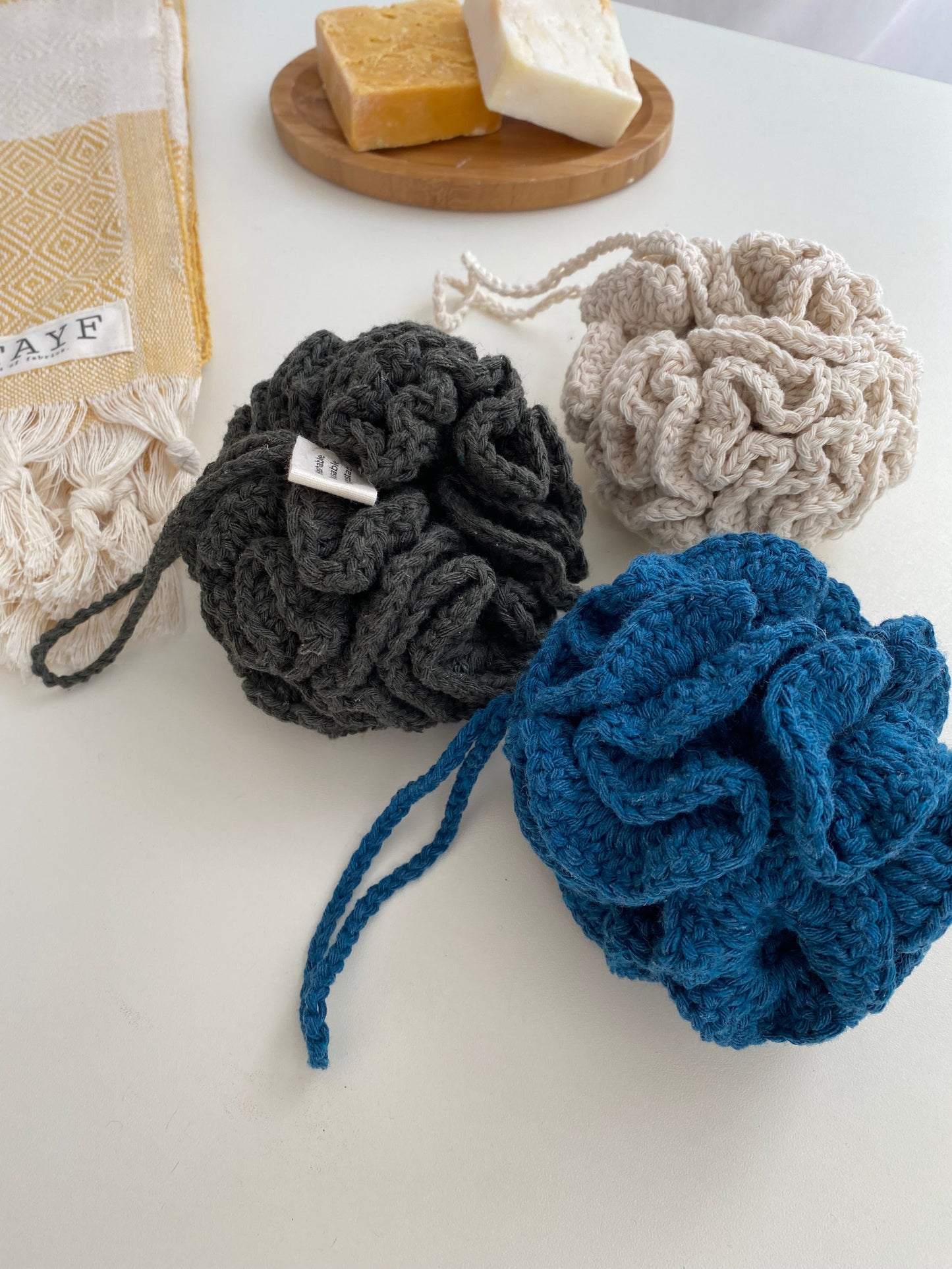 The Lefe Shower Flower — 100% Cotton Zero-Waste Sponge in olive, lifestyle shot, hanging from a showerhead