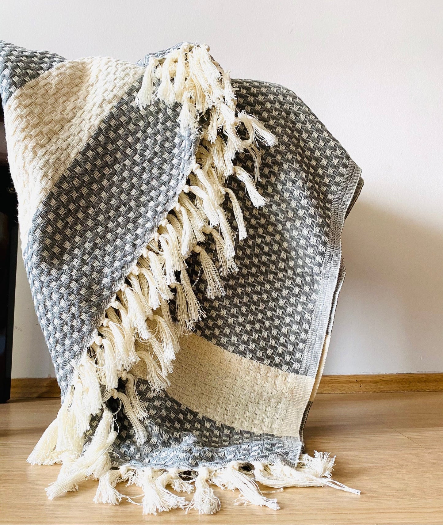 The Istanbul Handwoven Cotton blanket wrapped around a body on a bed
